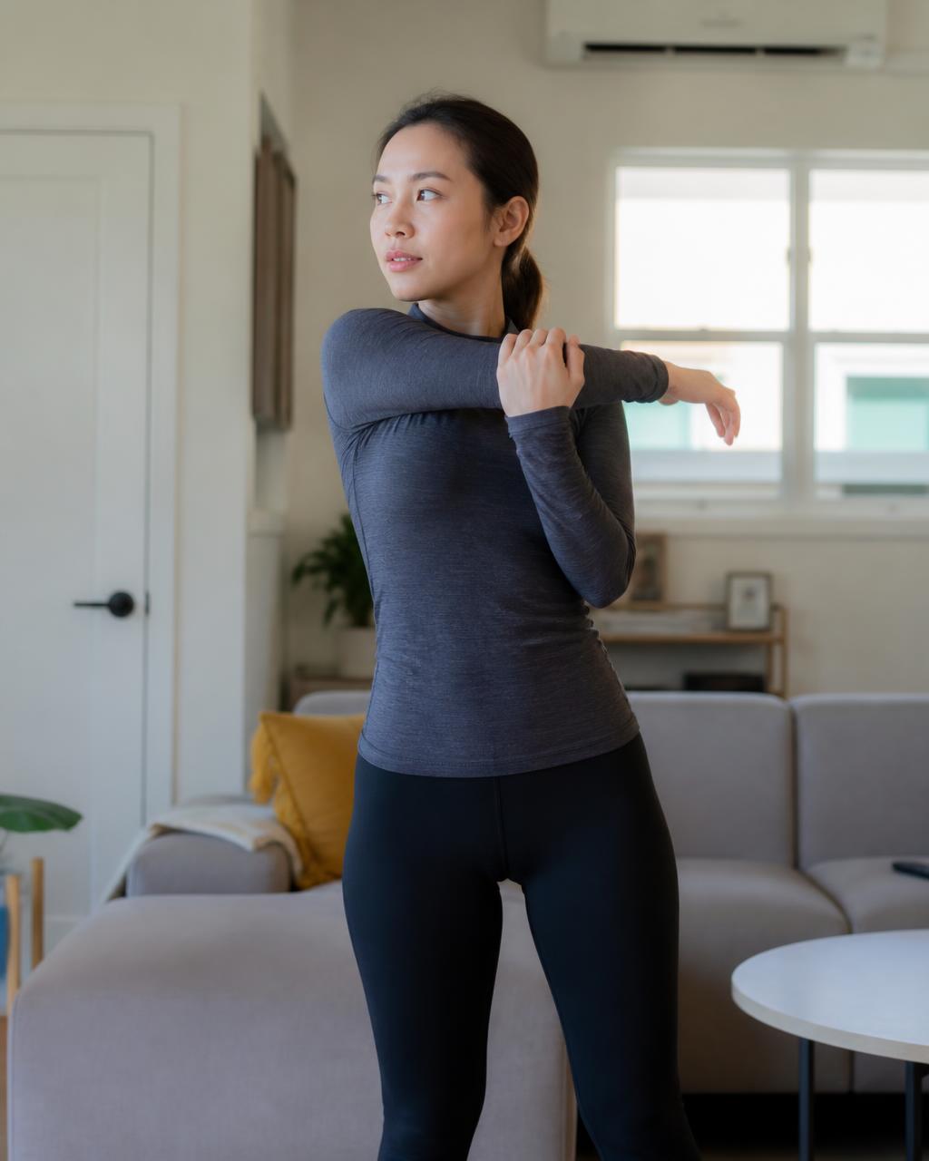 Woman doing a standing shoulder stretch at home