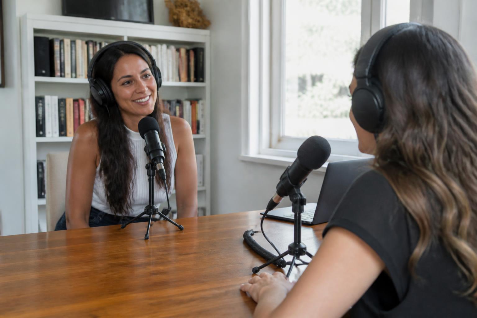 Two moms recording a podcast episode at a home studio
